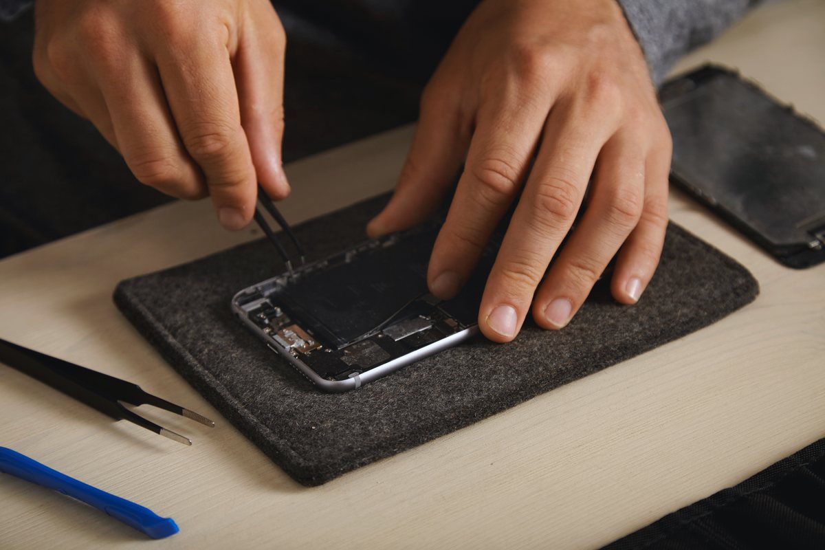 Technicien M'phone réparant un smartphone à domicile
